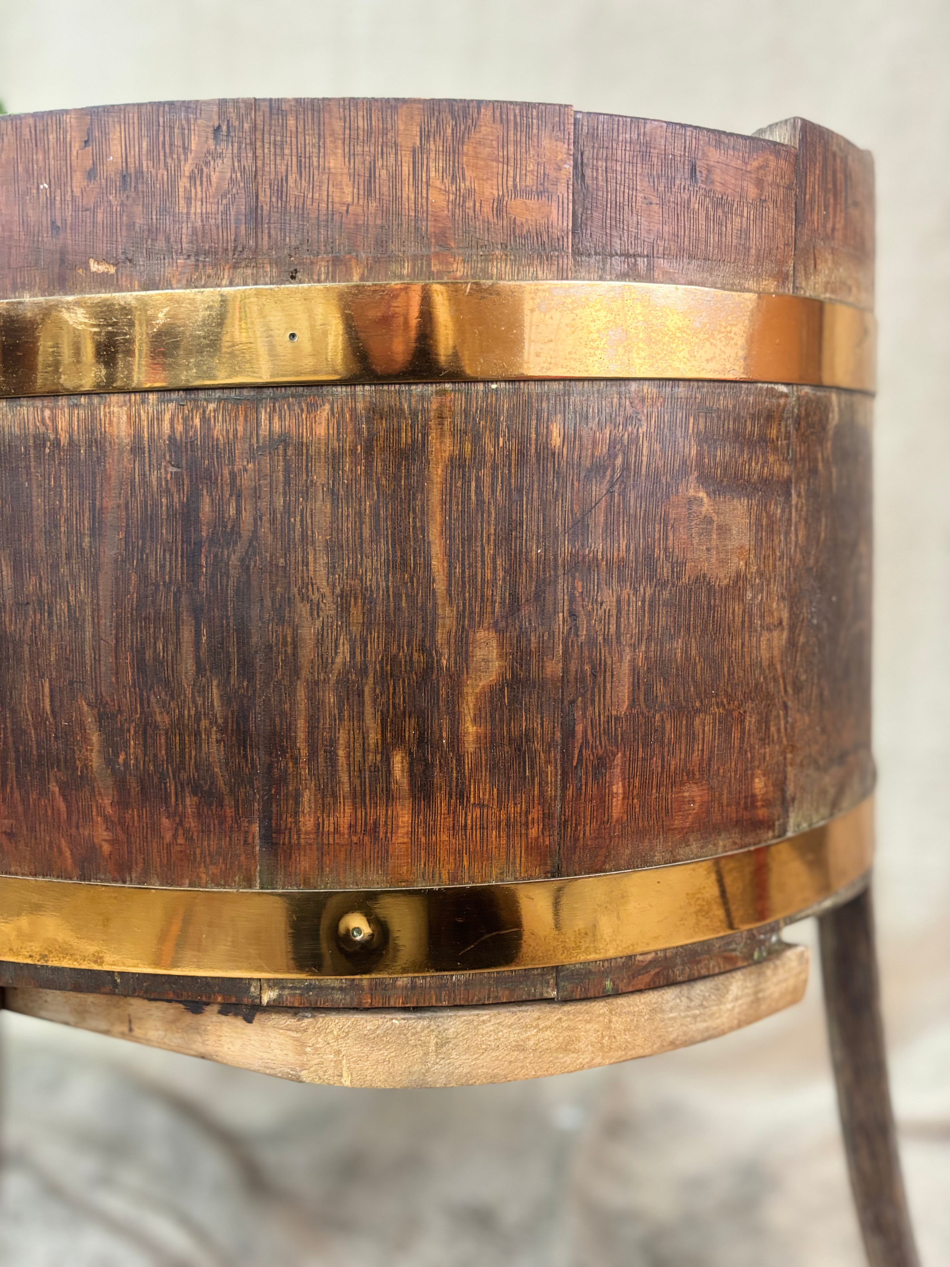 Wooden barrel with brass bands on a neutral background