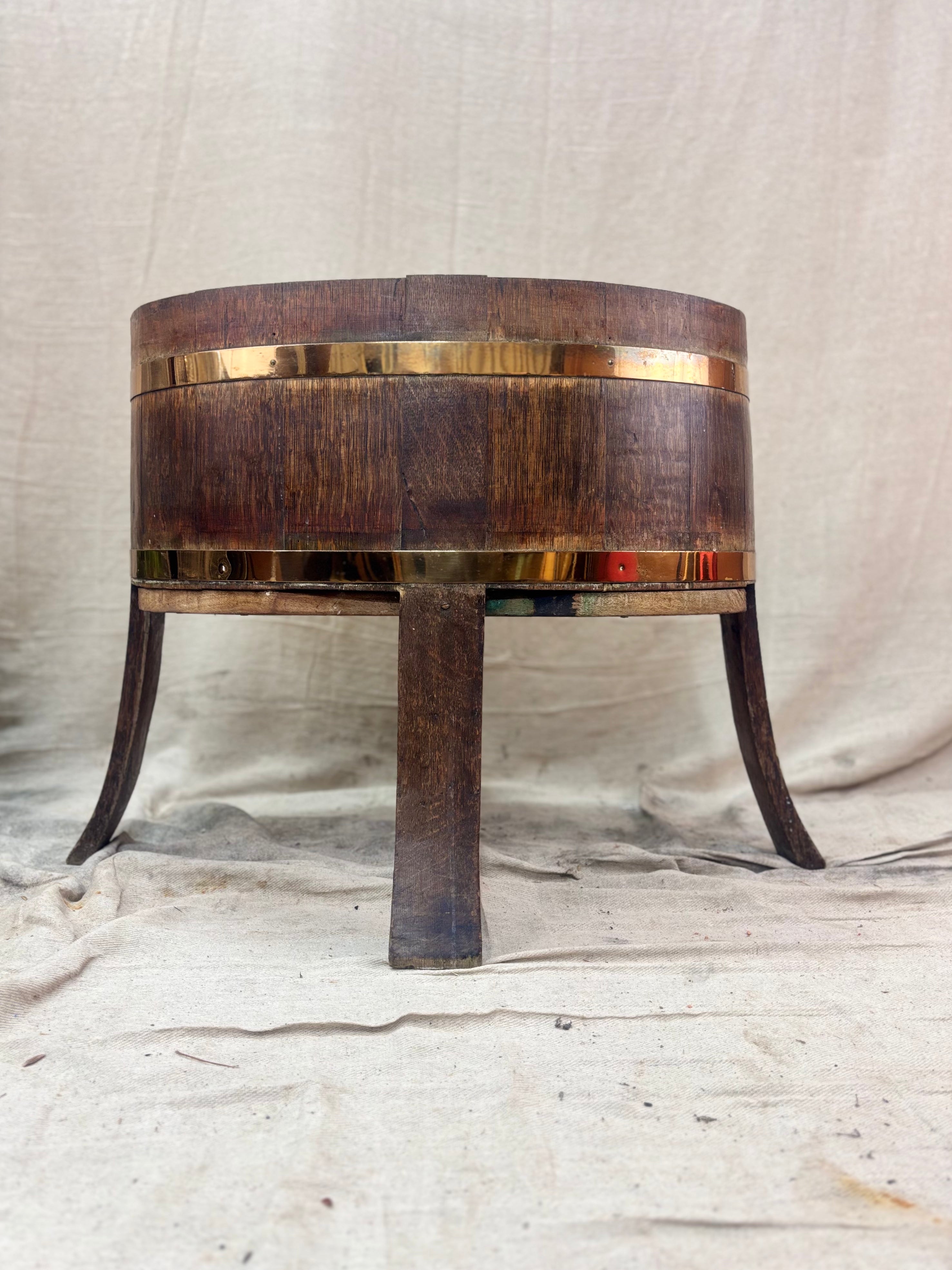 Wooden barrel-shaped table with metal legs on a textured surface