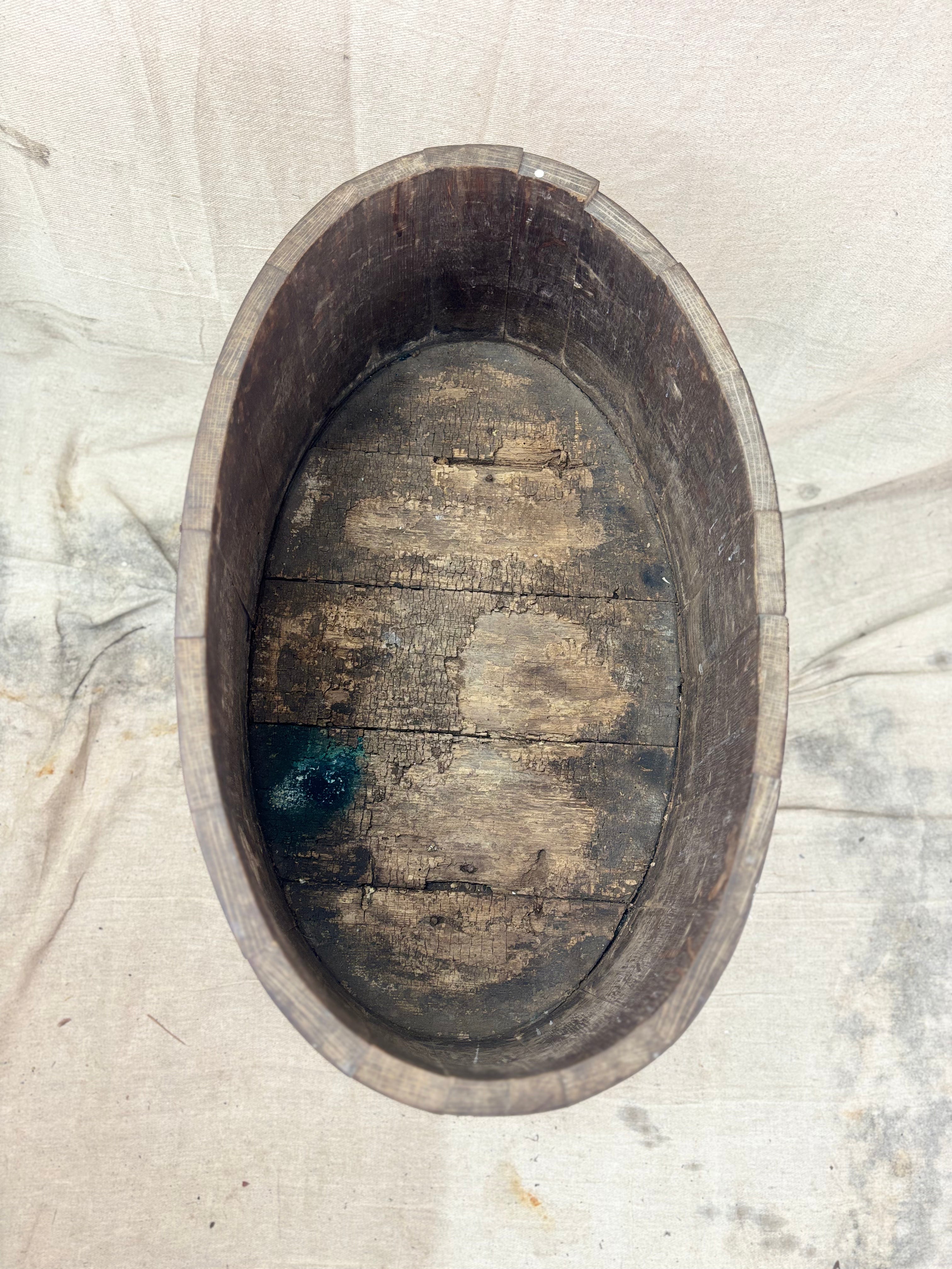 Wooden planter with peeling paint on a textured white background