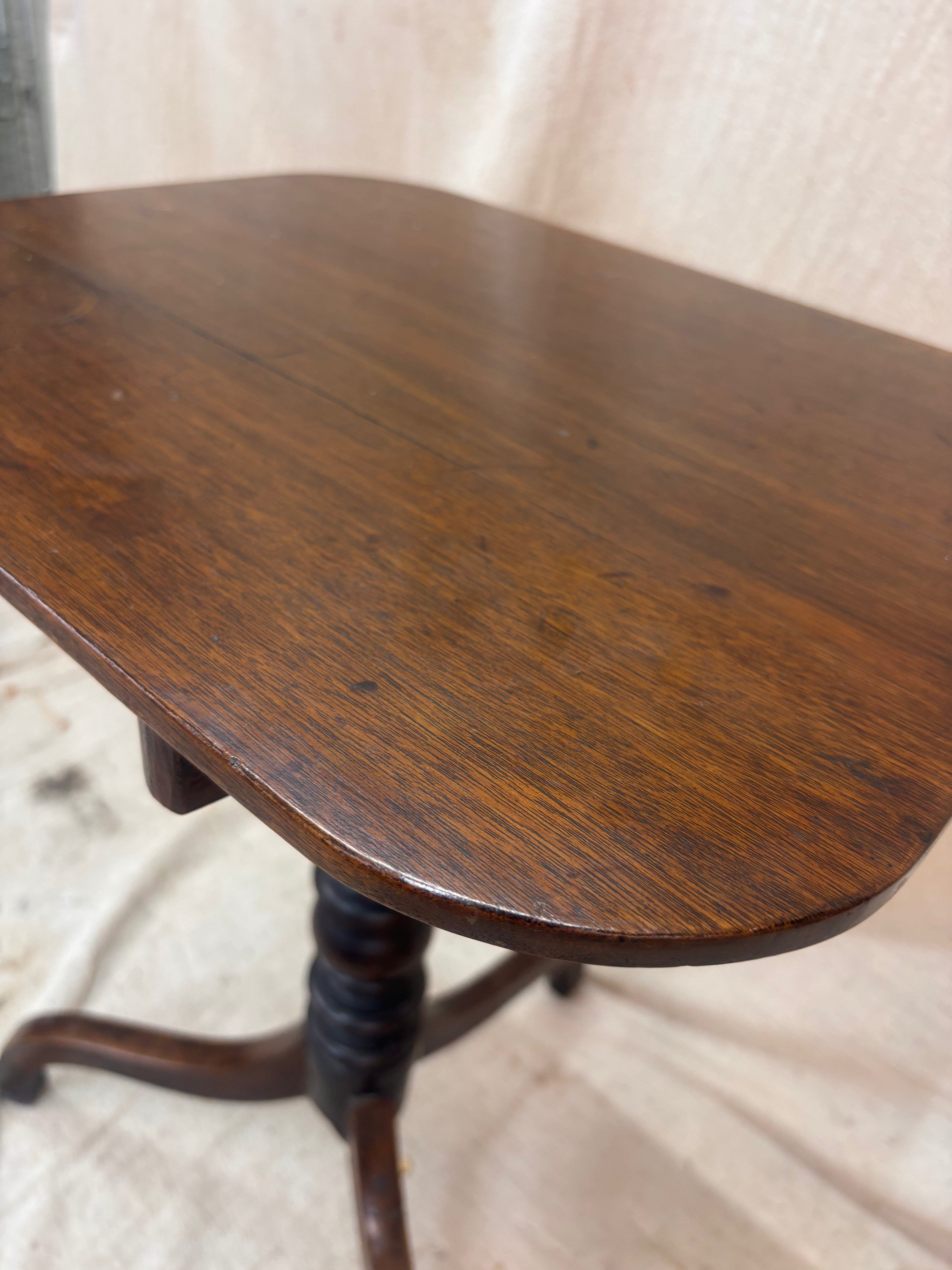 Wooden table with a single leg on a light background