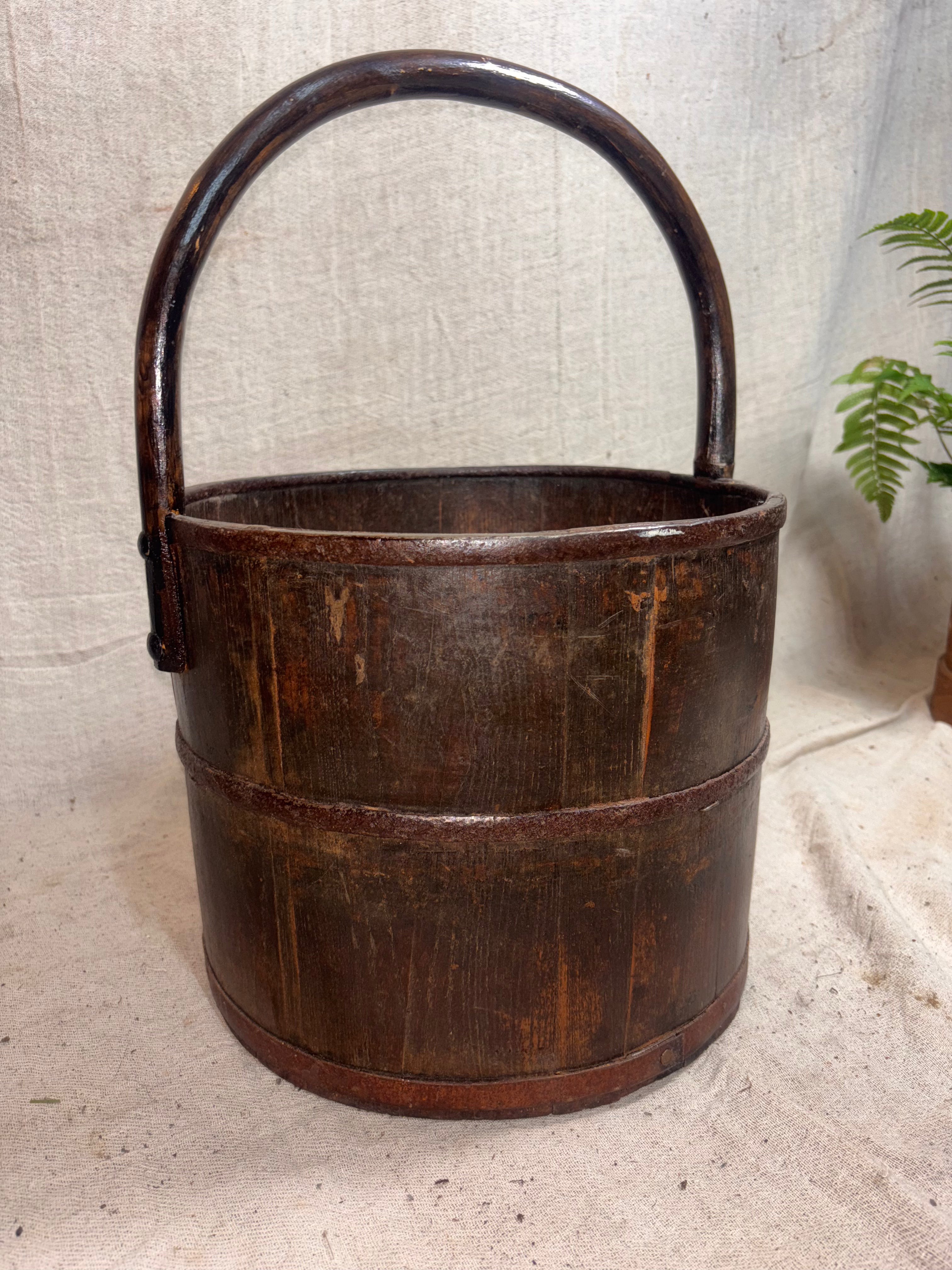 Wooden bucket with a handle on a textured surface