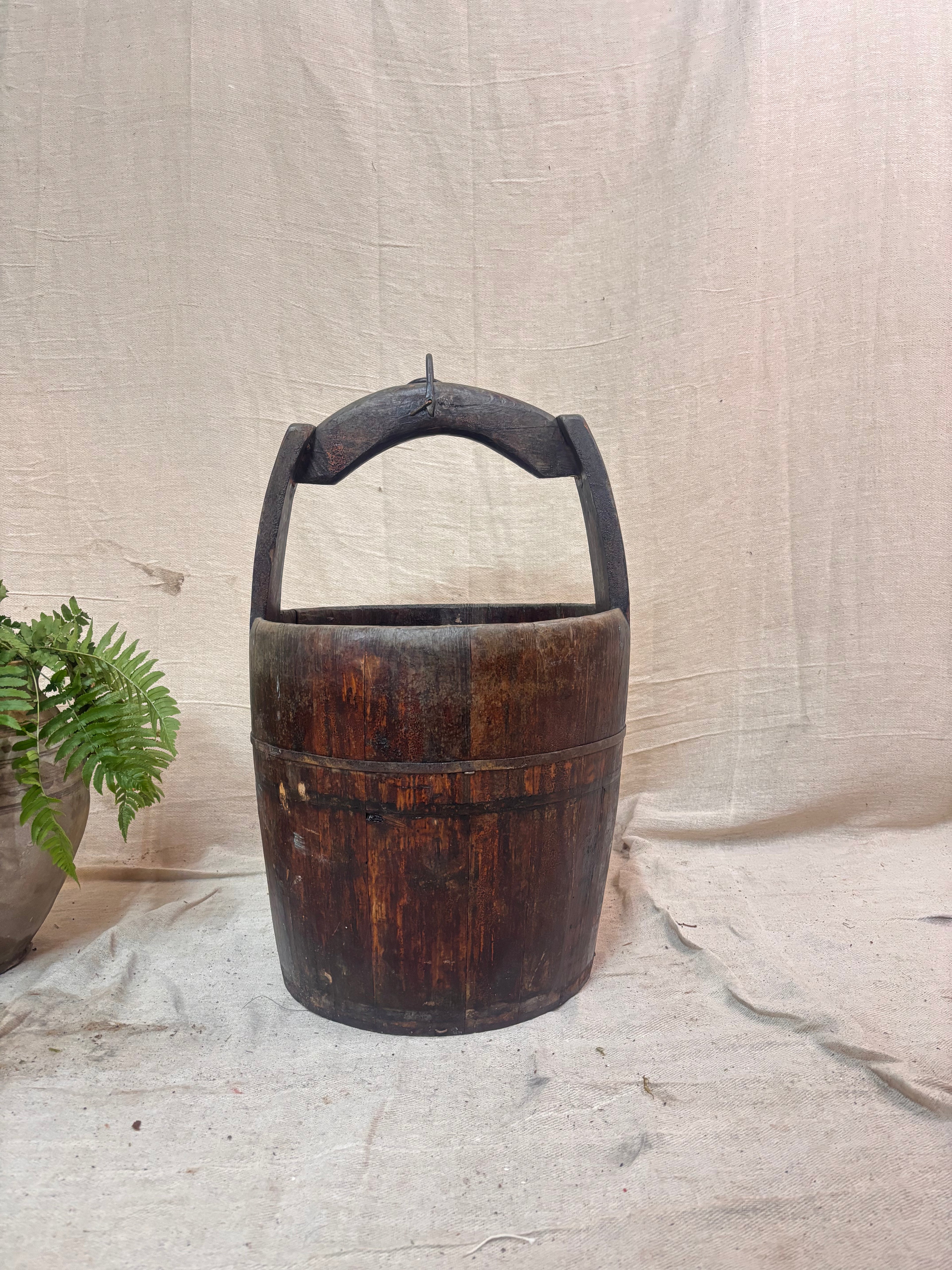 Vintage wooden well bucket with metal bands
