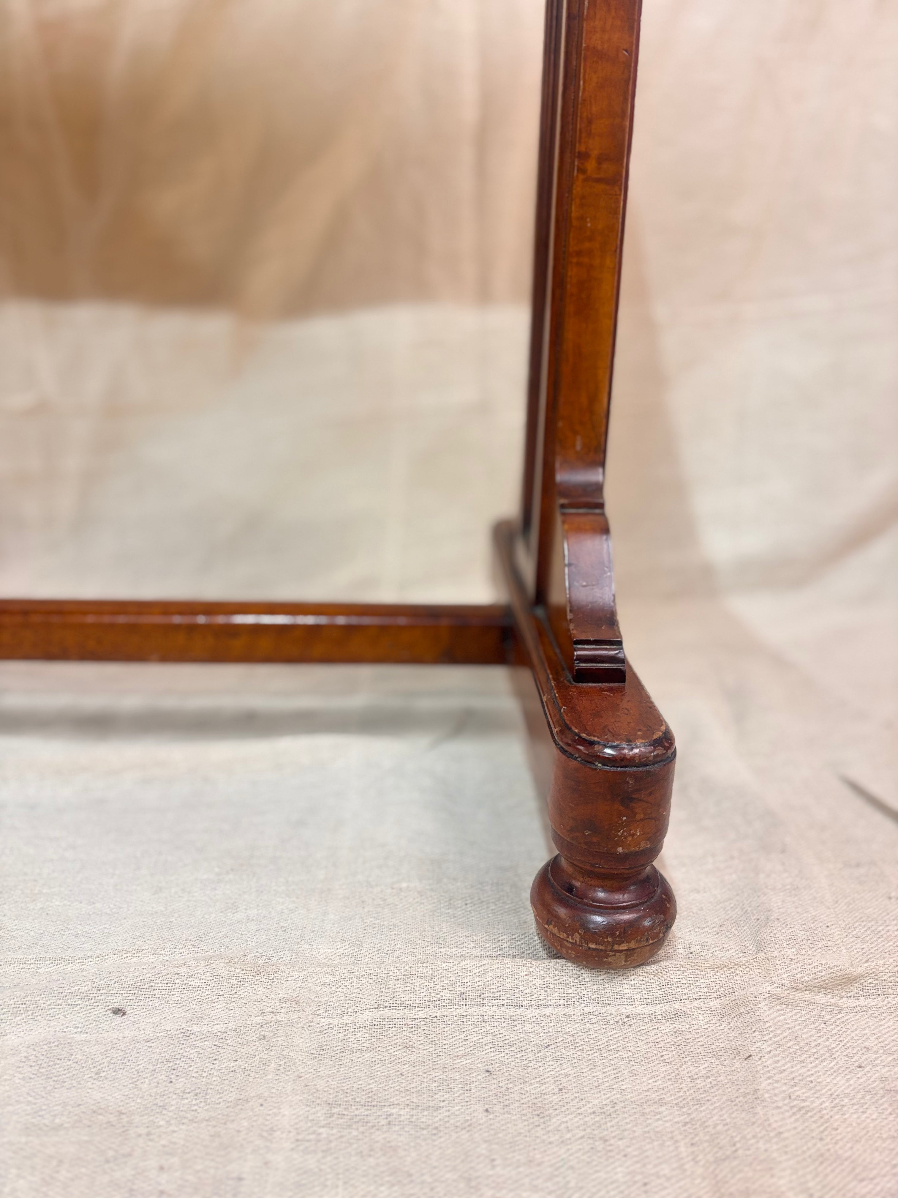 A small wooden table leg against a cream background 