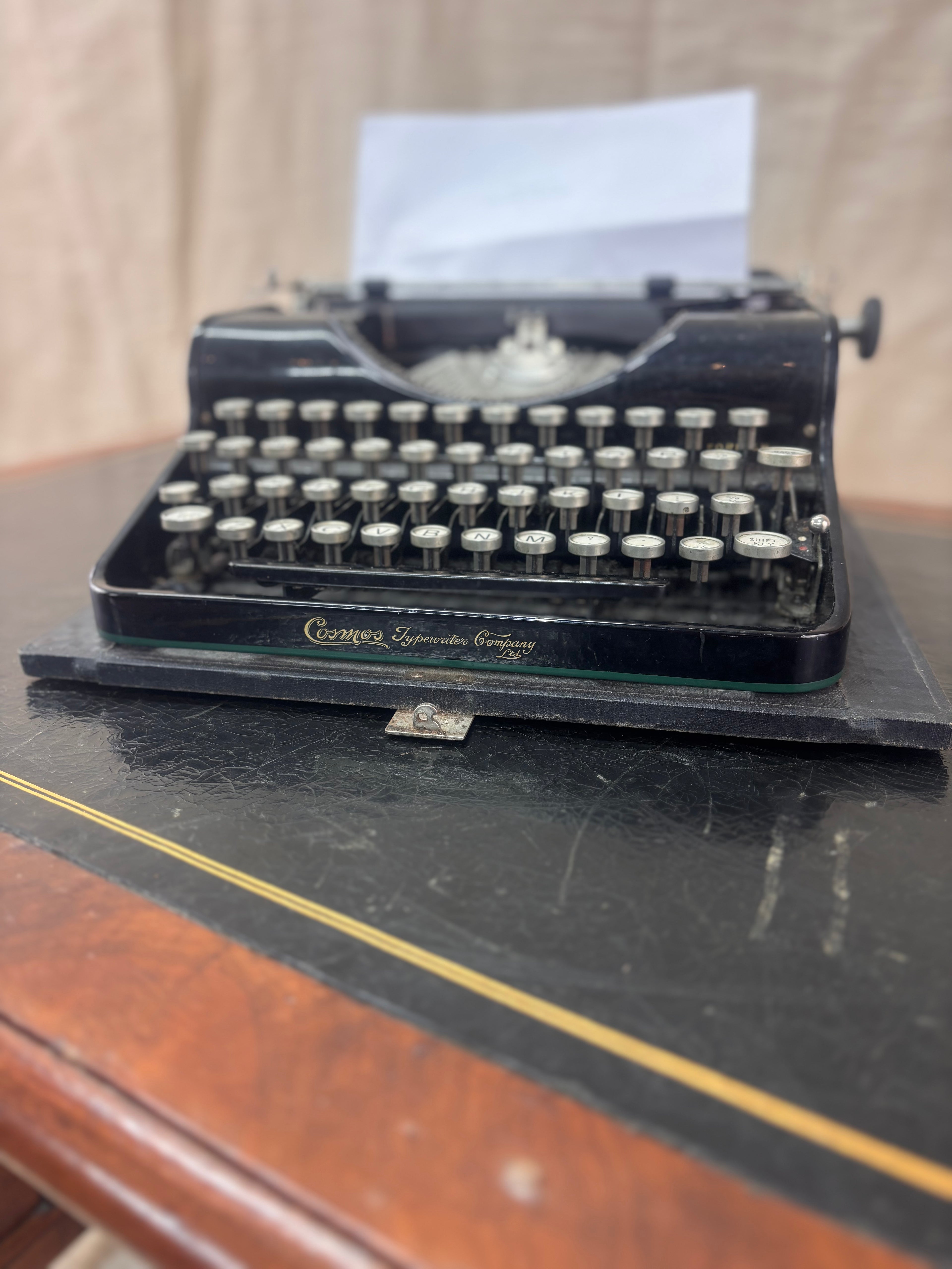 a vintage type writer on a leather top desk