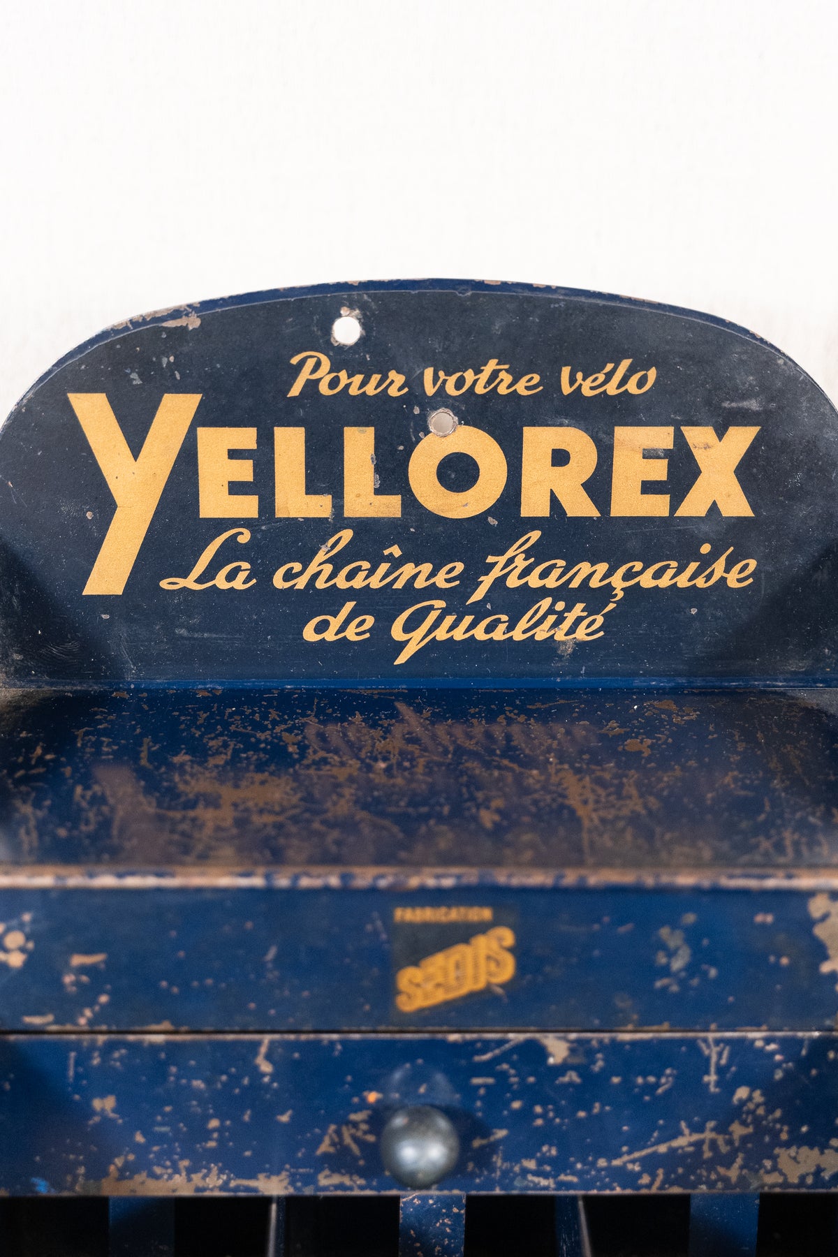 A vintage blue metal sign or decorative panel with gold lettering reading 'Pour votre velo YELLOREX La chaine française de Qualité' and a small 'SÉDUS' mark near the bottom, shown against a plain light background.