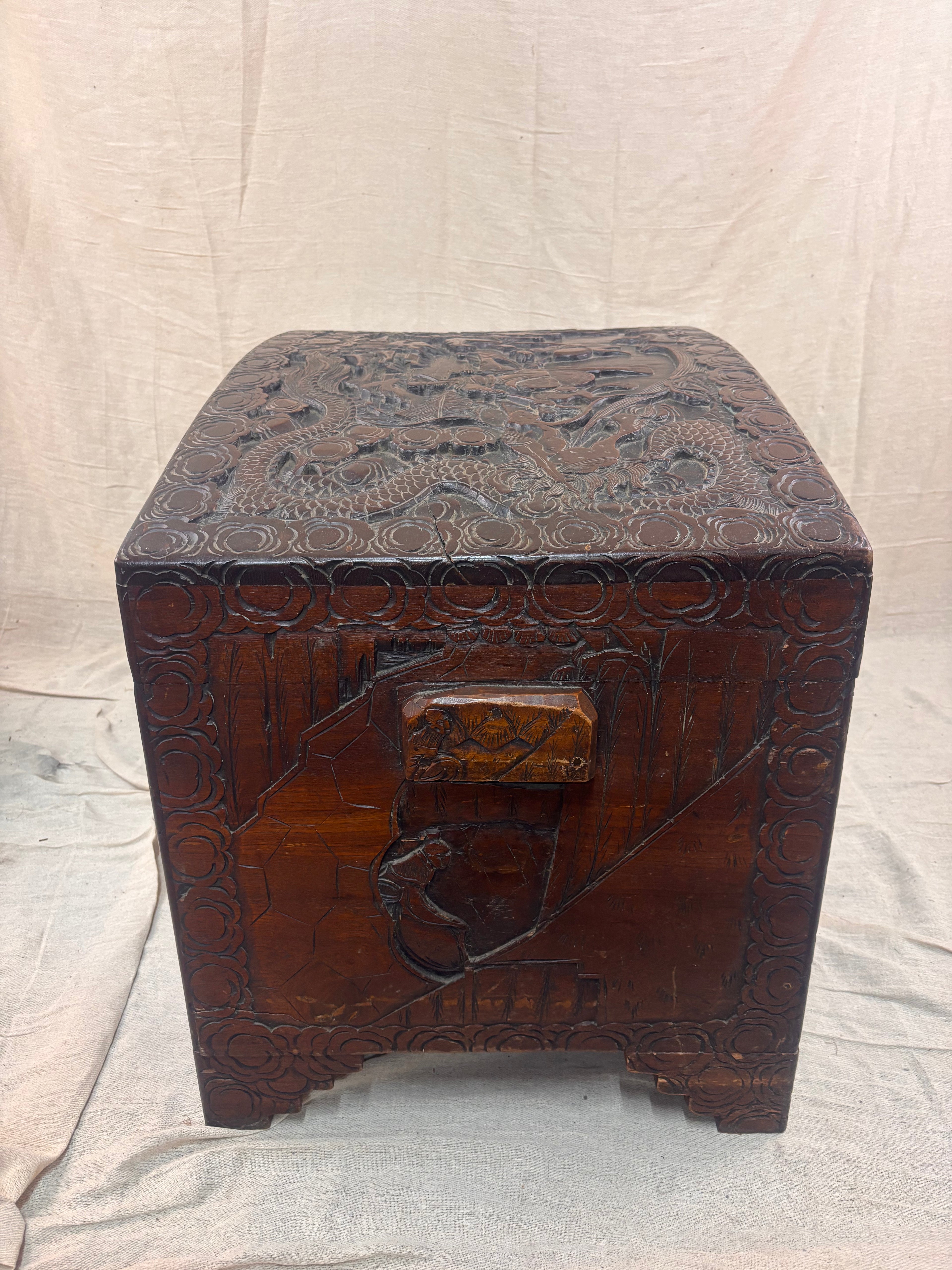 A carved wooden chest with a curved lid and small handle