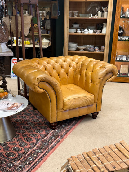 yellow leather chesterfield sofa in a store setting with shelves and products in the background.