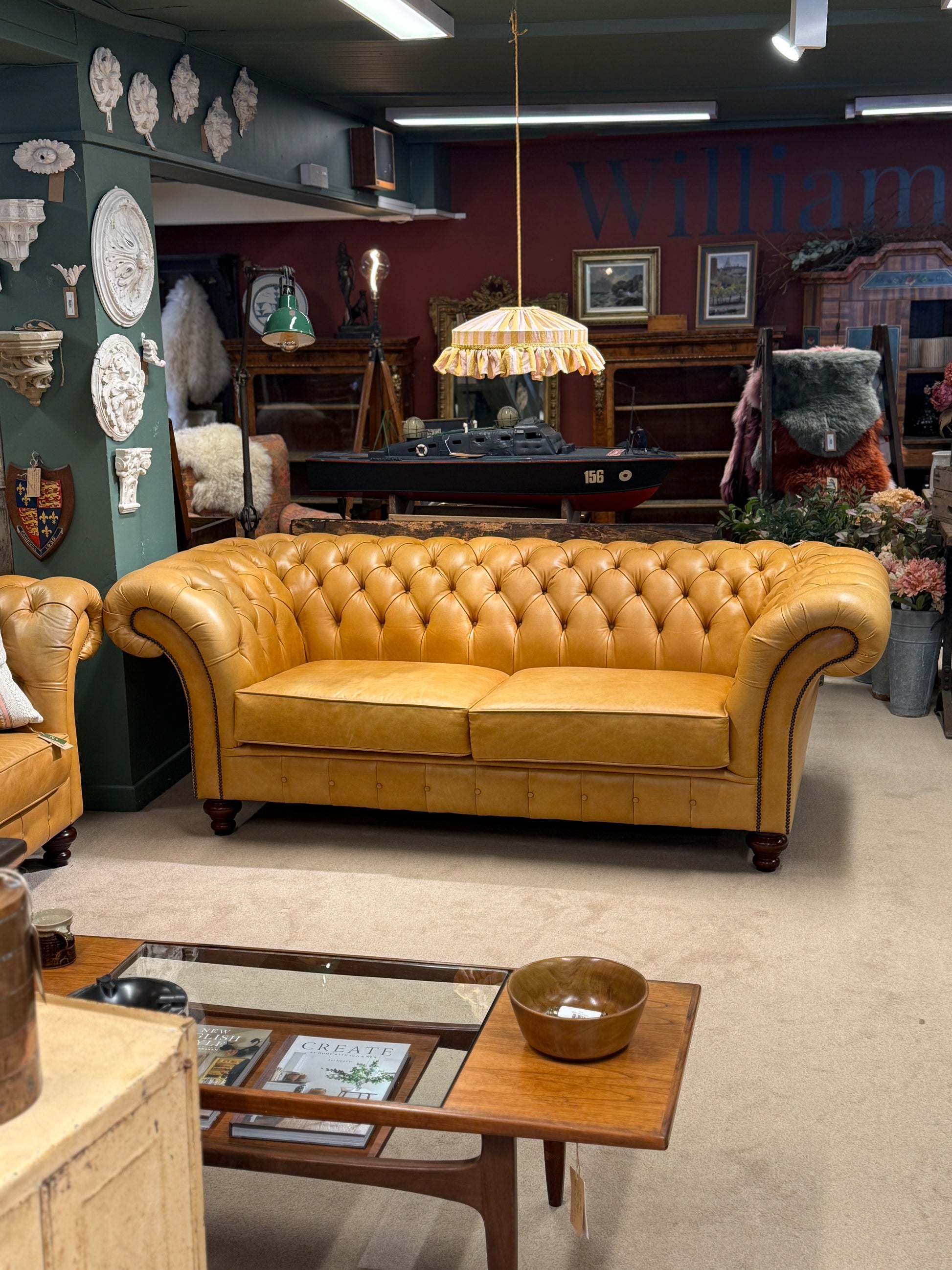 mustard leather sofa in a room with decorative elements and furniture.
