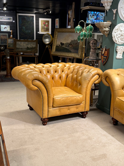 Two mustard leather armchairs in a room with various decor items.