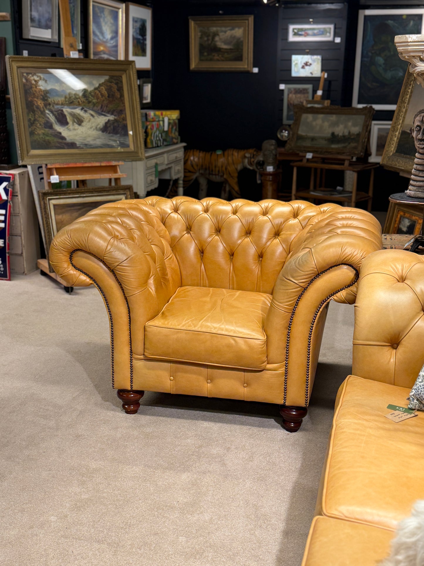 yellow leather sofa in a room with various artworks on the walls.