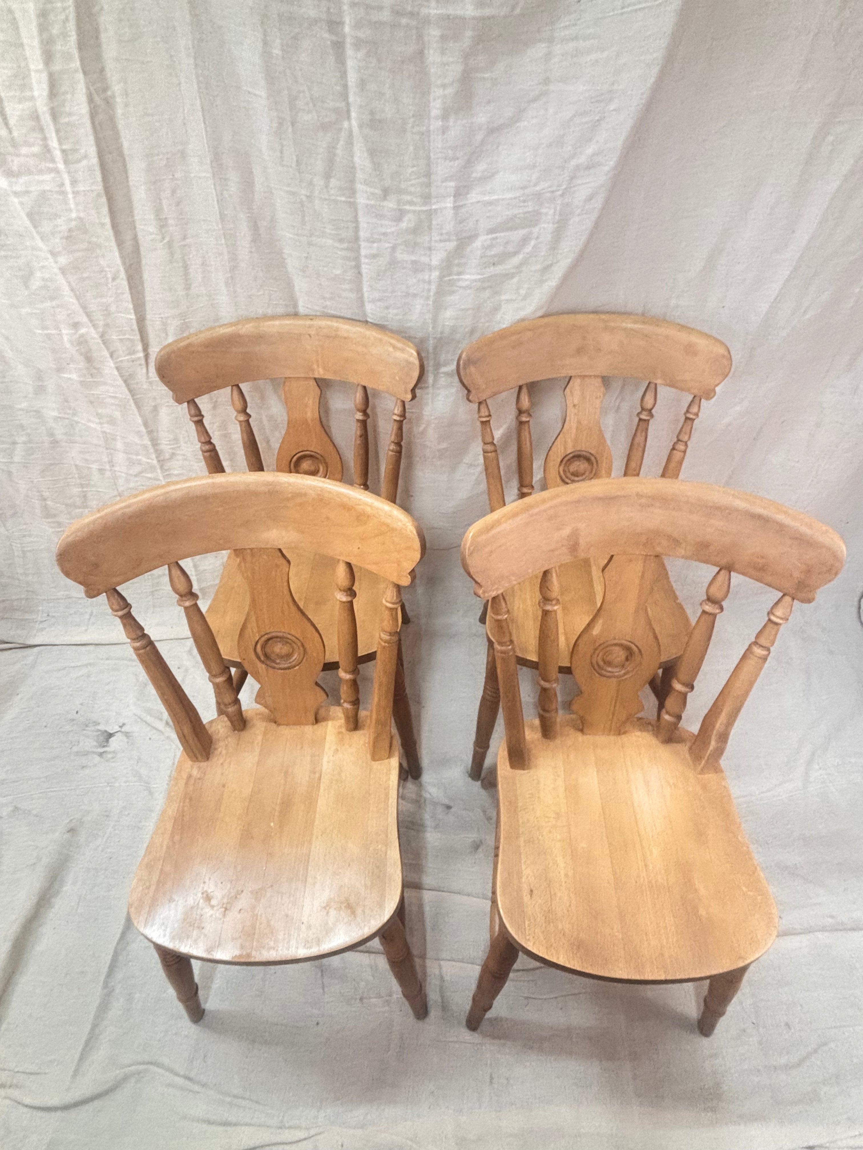 4 wooden chairs on a cream background