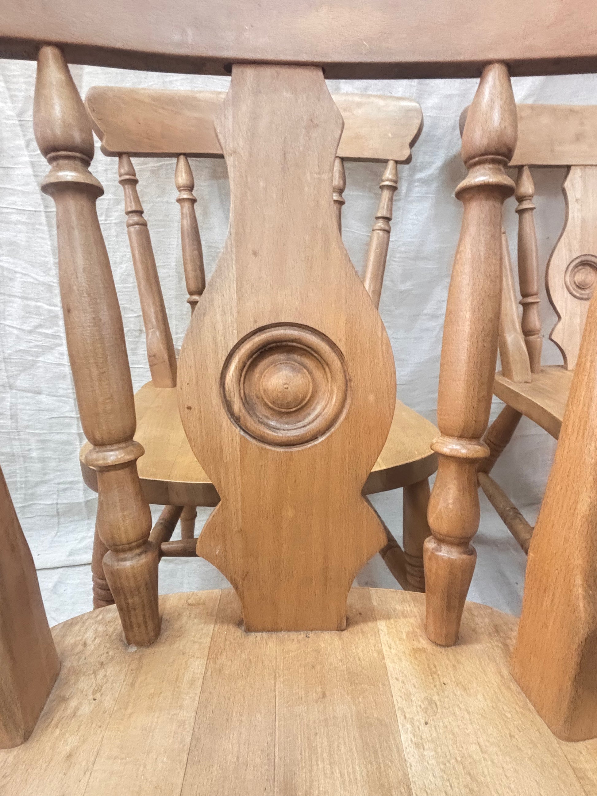 carved detail on a wooden chair with other chairs in the background