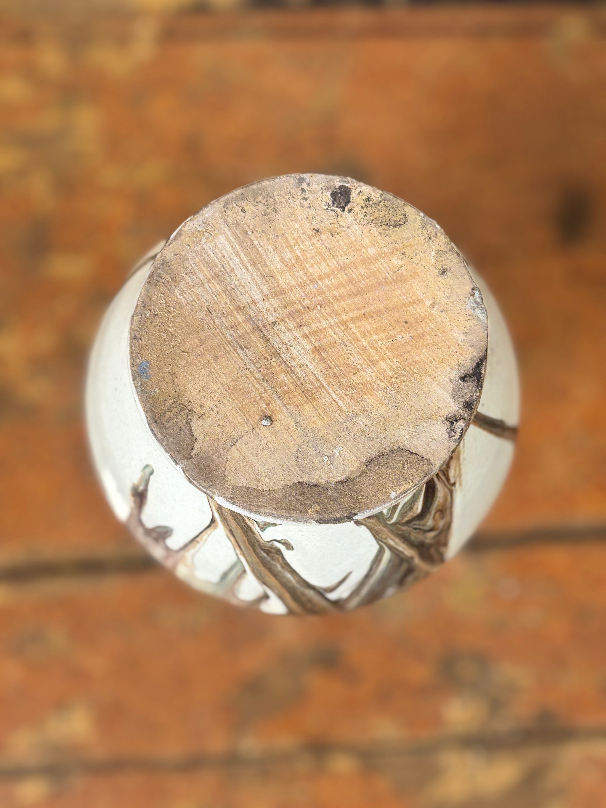 Close-up of ceramic vase base  on a wooden surface