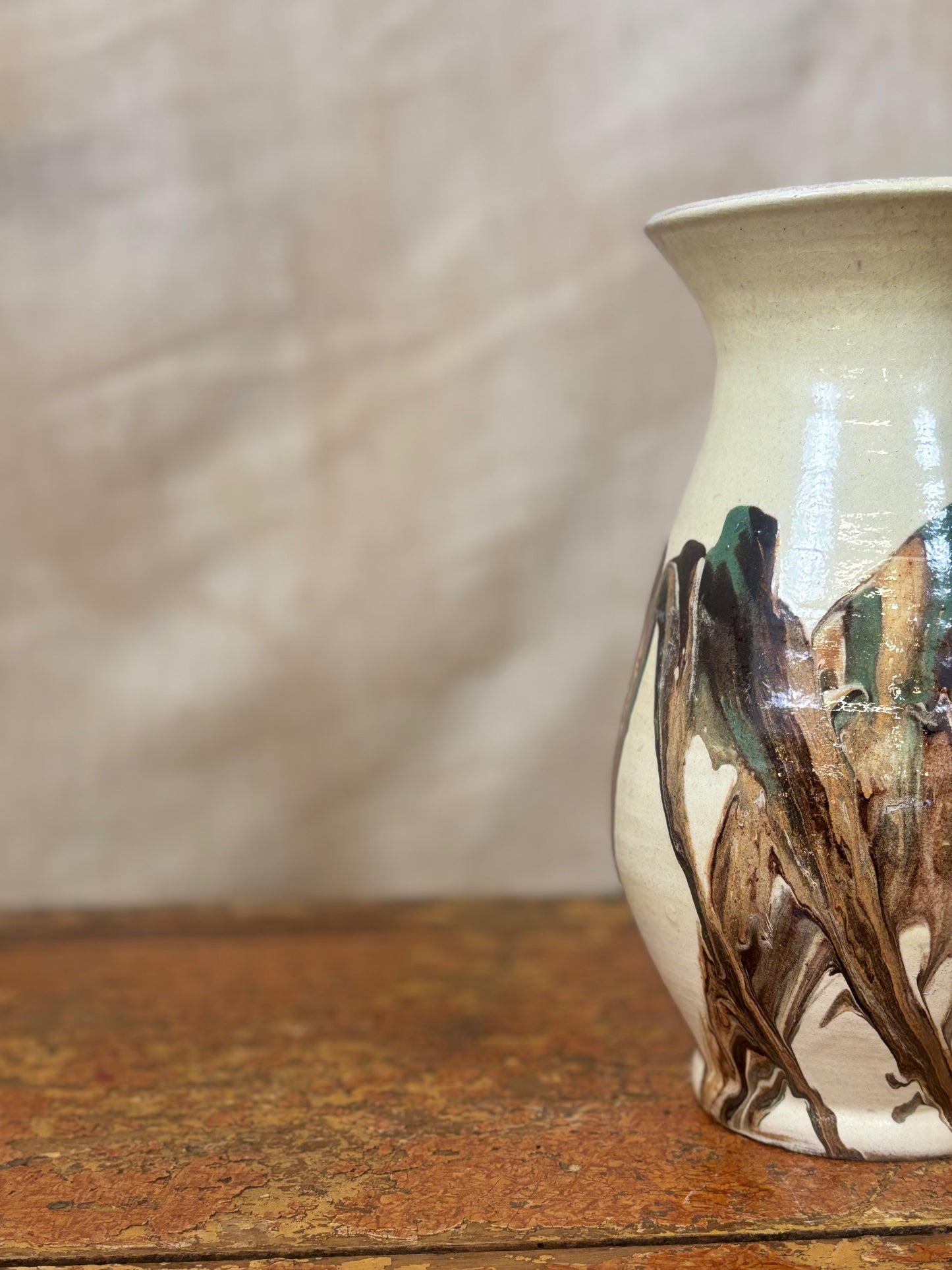 Ceramic vase with artistic design on a wooden surface