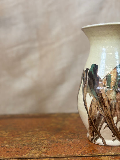 Ceramic vase with artistic design on a wooden surface