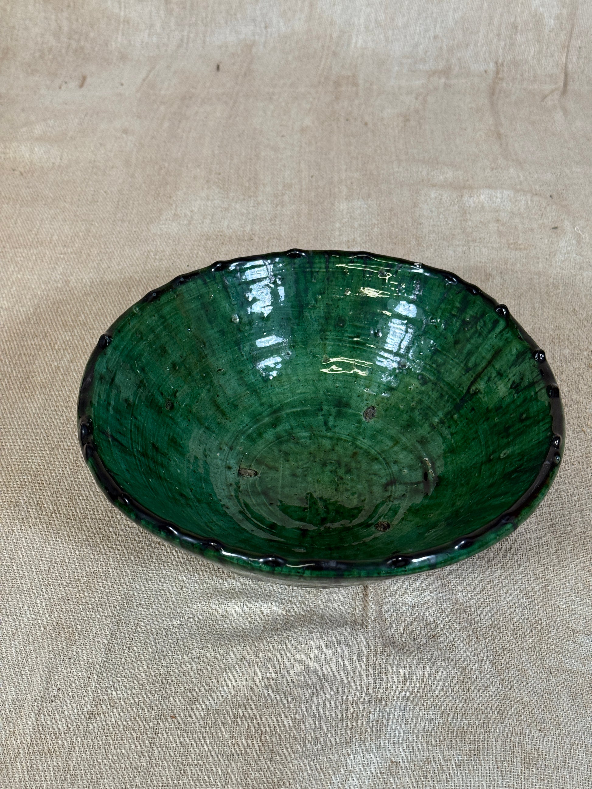 Green ceramic plate on a beige fabric background