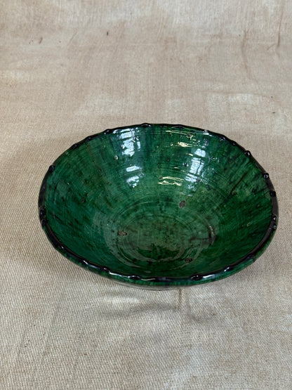 Green ceramic plate on a beige fabric background