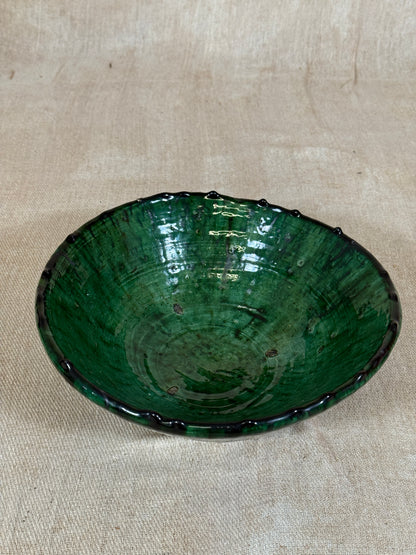 Greenish-brown bowl on a beige fabric background