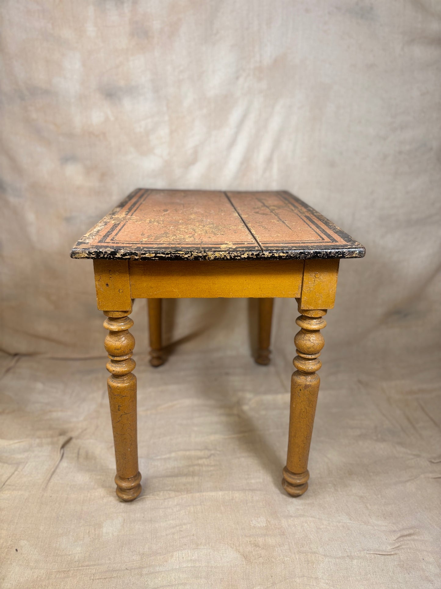 Wooden table with decorative top on a plain background