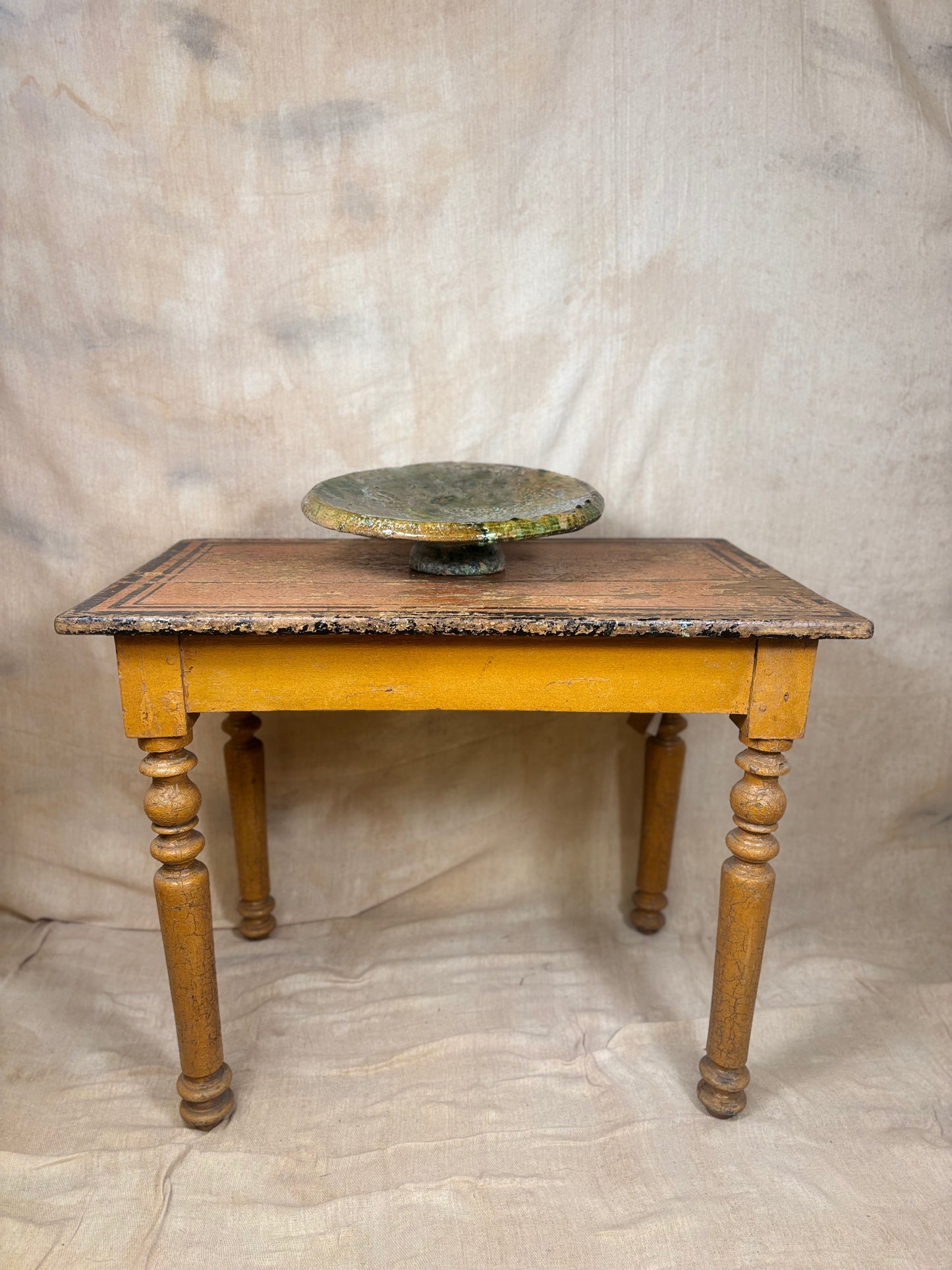 Small wooden table with a marble top against a plain background