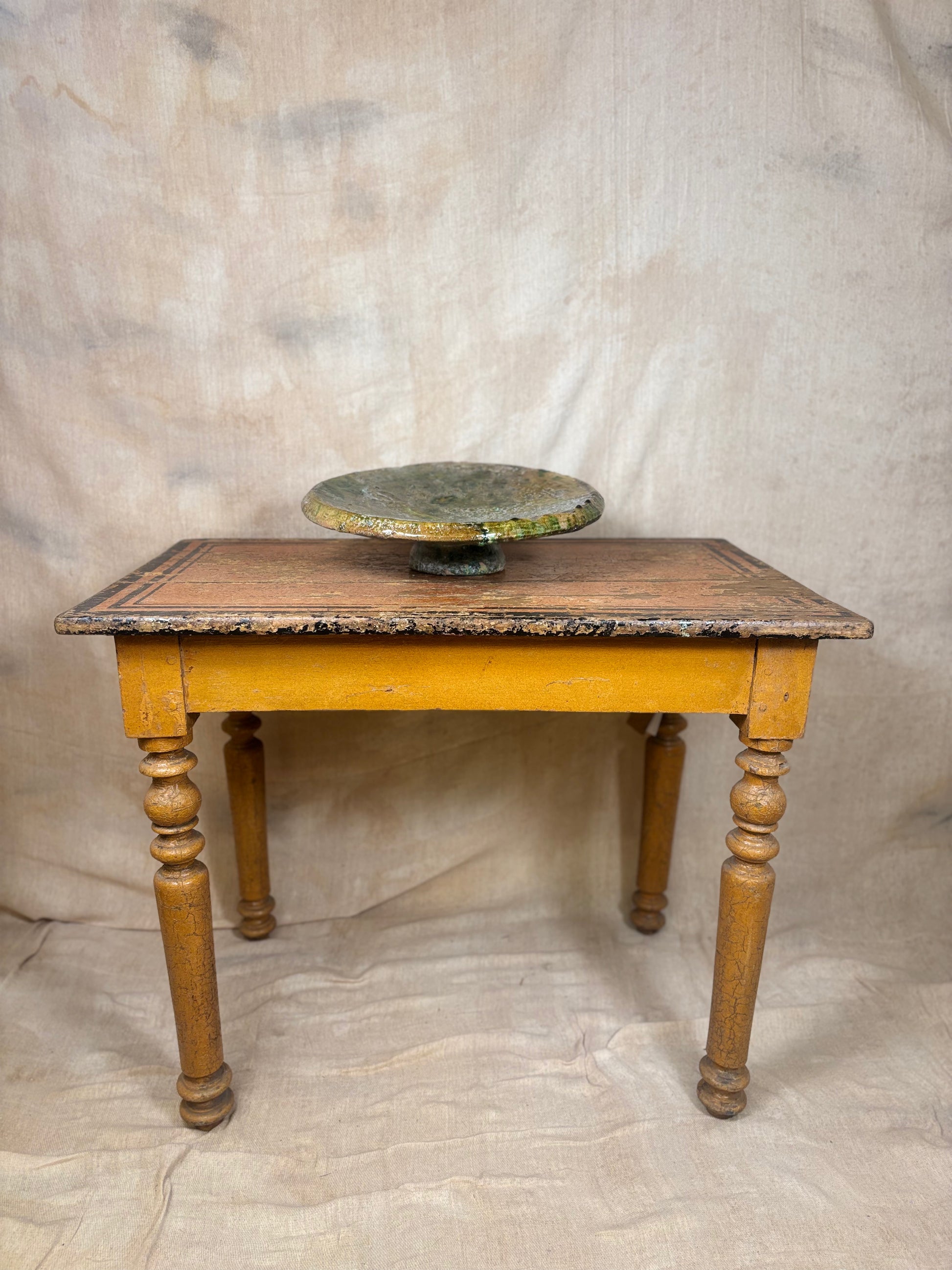Small wooden table with a marble top against a plain background